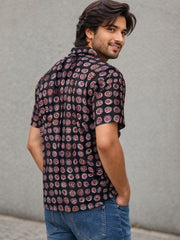 Man wearing a patterned Jahota Printed Cotton shirt and jeans against a gray background