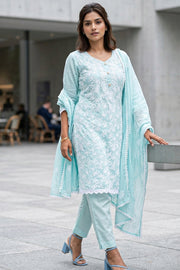Woman wearing a light blue traditional outfit with a matching dupatta in an urban setting - 10076188
