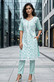 Woman wearing a light blue floral chikankari embroidered kurta with matching pants on a city street 10076188